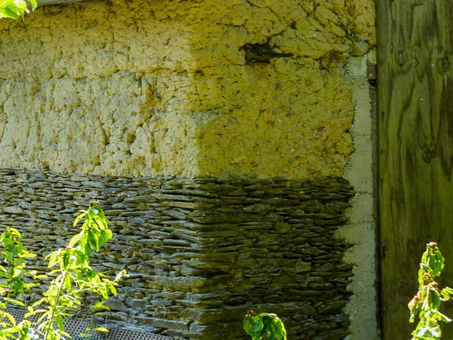 La Ville Aubrée : mur en bauge sur petits schistes.
Forme de construction très ancienne.